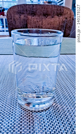 close-up photo of a glass of water on a white table close-up photo of a glass of water on a white table 140178127
