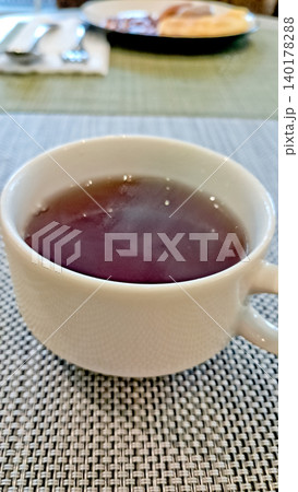 close up photo of a cup of tea on a white table close up photo of a cup of tea on a white table 140178288