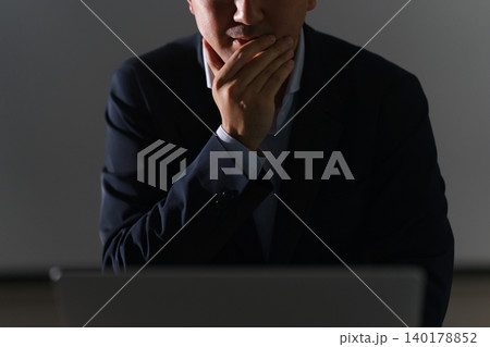 暗い室内でノートパソコンを見て違法アップロードサイトを検索して視聴する顔無しの会社員の男性 暗い室内でノートパソコンを見て違法アップロードサイトを検索して視聴する顔無しの会社員の男性 140178852