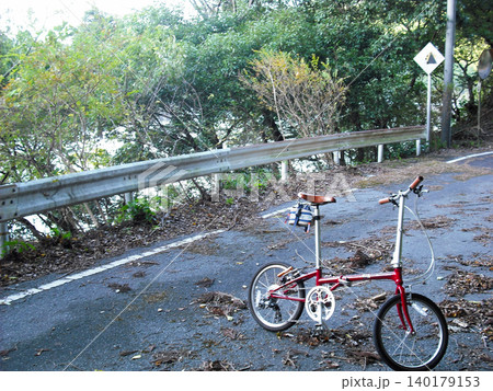 山道の林道に佇む赤い折りたたみ自転車 140179153