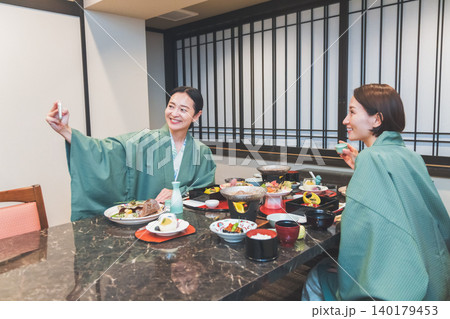温泉旅館の夕食時に笑顔で記念写真を撮影する浴衣姿の女性 温泉旅館の夕食時に笑顔で記念写真を撮影する浴衣姿の女性 140179453