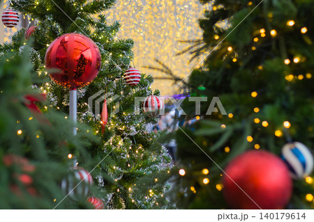 two christmas trees decorated with red and white balls with a giant wall of glowing golden lights in the middle two christmas trees decorated with red and white balls with a giant wall of glowing golden lights in the middle 140179614