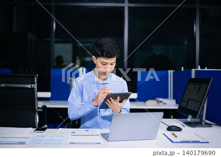 Confident business expert attractive smiling young man typing laptop and holding digital tablet 140179690