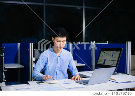Professional Asian businessman in suit working at office desk with laptop in modern corporate office, representing leadership, success, productivity, and business strategy. Professional Asian businessman in suit working at office desk with laptop in modern corporate office, representing leadership, success, productivity, and business strategy. 140179710