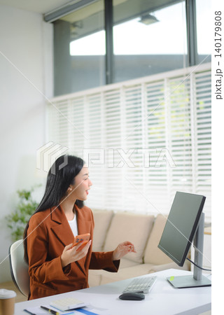 Asian businesswoman working at desk in modern office using smartphone and computer, professional corporate lifestyle Asian businesswoman working at desk in modern office using smartphone and computer, professional corporate lifestyle 140179808