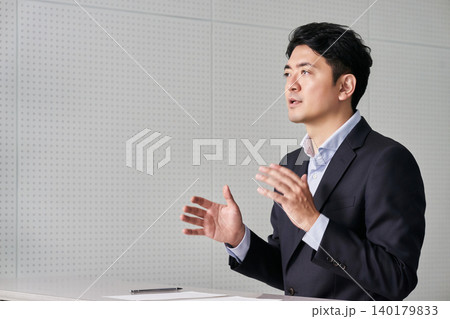 ジェスチャーや身振り手振りで説明をする30代の日本人の男性のビジネスマン ジェスチャーや身振り手振りで説明をする30代の日本人の男性のビジネスマン 140179833