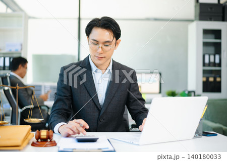 justice and law concept.businessman or lawyer or accountant working on accounts using a smart phone laptop digital tablet calculator justice and law concept.businessman or lawyer or accountant working on accounts using a smart phone laptop digital tablet calculator 140180033