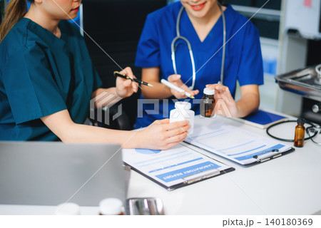 Medical team of doctors and a nurse using laptops in hospital office. Collaboration, diagnosis, and modern technology meet 140180369