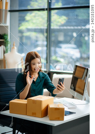 Asian woman prepares parcels and checks online orders on tablet and laptop for delivery online shopping Asian woman prepares parcels and checks online orders on tablet and laptop for delivery online shopping 140181095