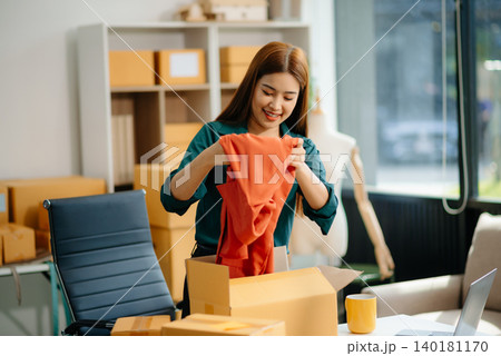 Young Asian women selling clothes on video streaming.Startup small business SME, using smartphone Young Asian women selling clothes on video streaming.Startup small business SME, using smartphone 140181170