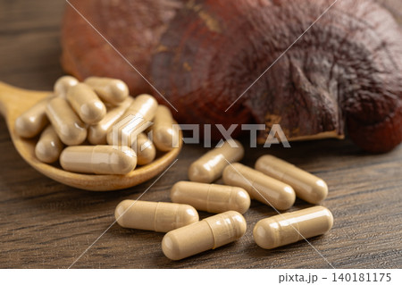 Dried lingzhi mushroom with capsule drug, alternative medicine herbal organic herb. Dried lingzhi mushroom with capsule drug, alternative medicine herbal organic herb. 140181175