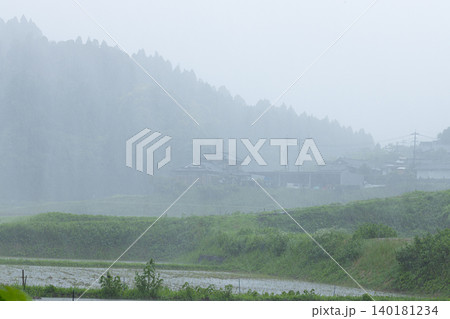 山間に降る大雨 自然豊かな風景と豪雨の中の民家 山間に降る大雨 自然豊かな風景と豪雨の中の民家 140181234
