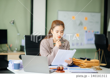 Asian Female judge in a courtroom on white table and Counselor or Male lawyer working in office. Asian Female judge in a courtroom on white table and Counselor or Male lawyer working in office. 140181311