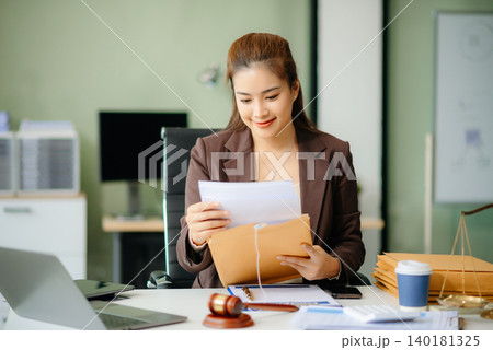 Asian Female judge in a courtroom on white table and Counselor or Male lawyer working in office. 140181325