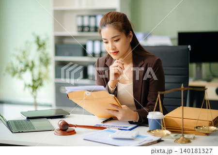 Asian Female judge in a courtroom on white table and Counselor or Male lawyer working in office. 140181327