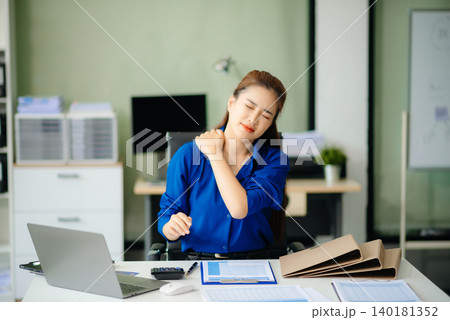 Overworked young Asian businesswoman office worker suffering from neck pain after had a long day Overworked young Asian businesswoman office worker suffering from neck pain after had a long day 140181352