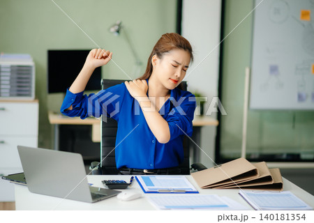 Overworked young Asian businesswoman office worker suffering from neck pain after had a long day Overworked young Asian businesswoman office worker suffering from neck pain after had a long day 140181354