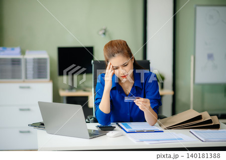 woman feeling migraine head strain.Overworked businesswoman financier while working on laptop and tablet 140181388