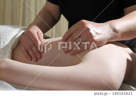 SPA salon and massage. Massage room. A massage therapist is working with a young woman.  140181621