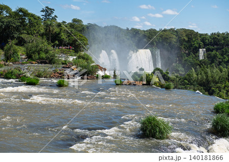Majestic iguazu falls pour massive water creating breathtaking mist over lush green nature Majestic iguazu falls pour massive water creating breathtaking mist over lush green nature 140181866