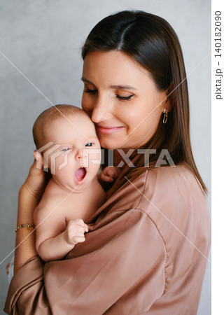 Gentle Mother Holding Yawning Newborn Baby In Arms 140182090