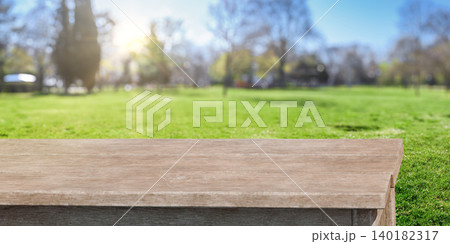 Wooden table with blurred green park background and sunlight 140182317
