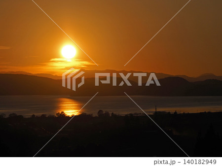 猪苗代湖対岸に沈む夕日。オレンジ色に輝く太陽と湖面が印象的で綺麗だ。 猪苗代湖対岸に沈む夕日。オレンジ色に輝く太陽と湖面が印象的で綺麗だ。 140182949