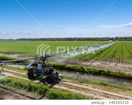 Autonomous machine is moving watering pivot along irrigation canal Autonomous machine is moving watering pivot along irrigation canal 140183218