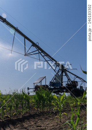 Autonomous machine is moving watering pivot along irrigation canal. Autonomous machine is moving watering pivot along irrigation canal. 140183302