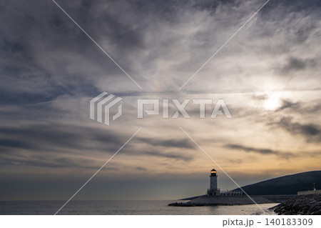 A lighthouse on the seashore with a dramatic sky A lighthouse on the seashore with a dramatic sky 140183309