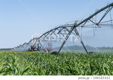Autonomous machine is moving watering pivot along irrigation canal. Autonomous machine is moving watering pivot along irrigation canal. 140183322