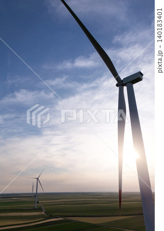 Aerial view of wind turbine on an agricultural filed at sunset. Close up of blades. 140183401