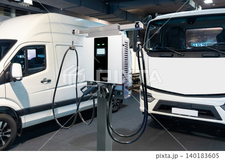Electric vehicles charging station on a background of trucks and van Electric vehicles charging station on a background of trucks and van 140183605