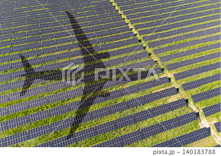 Aerial view of an airplane shadow cast across a solar panel field. Aerial view of an airplane shadow cast across a solar panel field. 140183788