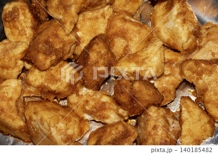 Well seasoned golden batter style chicken pieces fried and on some foil close up 140185482