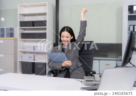 Successful business woman, excited young woman Keeping up arms and showing positive emotions, happy working in modern office on computer. Successful business woman, excited young woman Keeping up arms and showing positive emotions, happy working in modern office on computer. 140185675