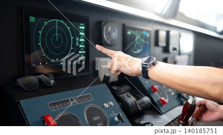 Captain hand pointing at marine radar monitor screen or GPS navigation map on boat dashboard Captain hand pointing at marine radar monitor screen or GPS navigation map on boat dashboard 140185751
