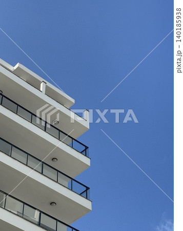 Modern architectural building facade against clear blue sky, suitable for background and design concepts Modern architectural building facade against clear blue sky, suitable for background and design concepts 140185938