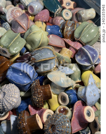 Ceramic sculptures of colorful sea urchins displayed in an artistic heap, showcasing texture Ceramic sculptures of colorful sea urchins displayed in an artistic heap, showcasing texture 140185948