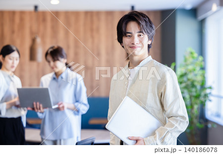 スタートアップ企業のオフィスで爽やかに微笑む若手社員 140186078