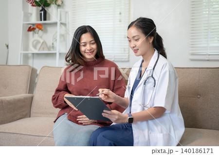 Woman doctor explaining body condition to asian pregnant patient sitting on sofa in hospital clinic. 140186171