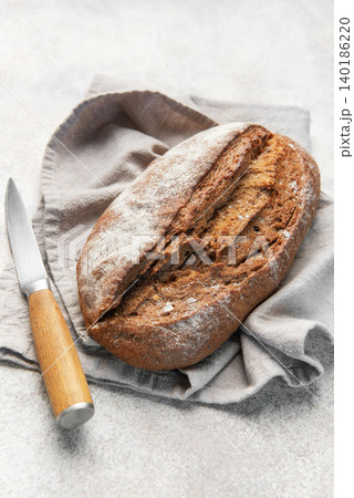 Homemade sourdough rye bread with knife on linen Homemade sourdough rye bread with knife on linen 140186220