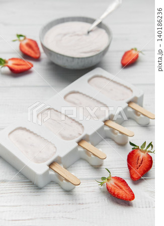 Homemade strawberry yogurt popsicles chilling in mold Homemade strawberry yogurt popsicles chilling in mold 140186236