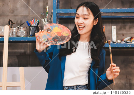 Female artist wears black hat posing near picture indoor the studio Female artist wears black hat posing near picture indoor the studio 140186526
