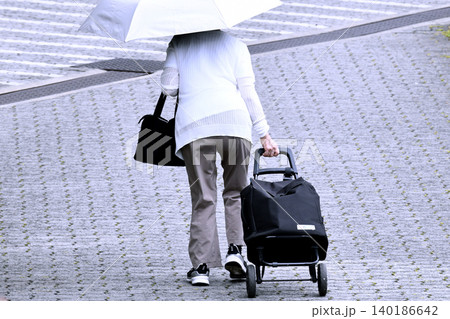 日本の横浜都市景観日傘を差し、荷物が入ったカートを引く高齢女性…段差…=横浜市内で 日本の横浜都市景観日傘を差し、荷物が入ったカートを引く高齢女性…段差…=横浜市内で 140186642