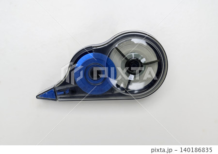 A single blue and transparent plastic correction tape dispenser or white-out roller isolated on a clean, light grey background, perfect for office and school stationery themes A single blue and transparent plastic correction tape dispenser or white-out roller isolated on a clean, light grey background, perfect for office and school stationery themes 140186835