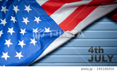 An American flag draped diagonally over a rustic blue painted wooden plank background with 4th July text, perfect for Independence Day celebrations An American flag draped diagonally over a rustic blue painted wooden plank background with 4th July text, perfect for Independence Day celebrations 140186850