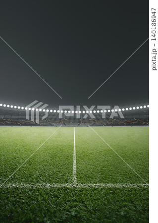 A professional vertical shot of an empty green grass soccer field at night, illuminated by stadium floodlights with a dark background A professional vertical shot of an empty green grass soccer field at night, illuminated by stadium floodlights with a dark background 140186947