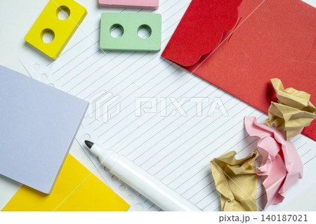 A top-down view of creative stationery including a white marker, sticky notes, crumpled paper, and colorful blocks on lined paper. Ideal for office, education, and brainstorming themes A top-down view of creative stationery including a white marker, sticky notes, crumpled paper, and colorful blocks on lined paper. Ideal for office, education, and brainstorming themes 140187021