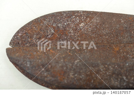 An extreme close-up showing the heavy rust and pitted texture on the blades of an old vintage pair of metal shears, highlighting corrosion and decay over time An extreme close-up showing the heavy rust and pitted texture on the blades of an old vintage pair of metal shears, highlighting corrosion and decay over time 140187057